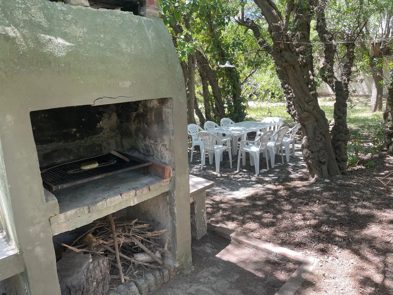 Parrilla con mesas y sillas de jardín en Balneario Reta